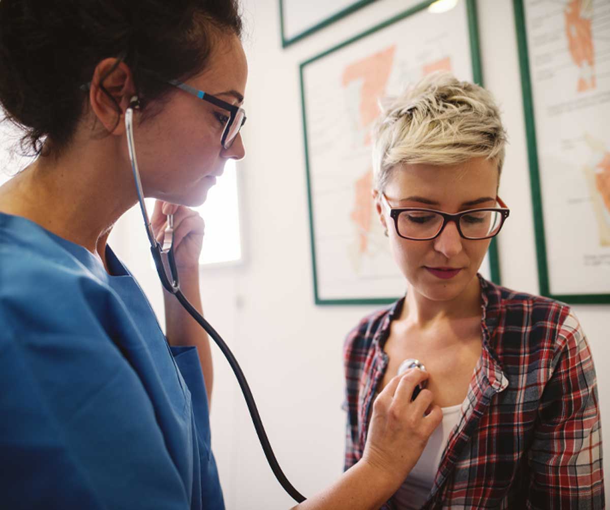 Nurse listens to patient's heart