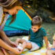 mom putting a bandage on her son's skid knee